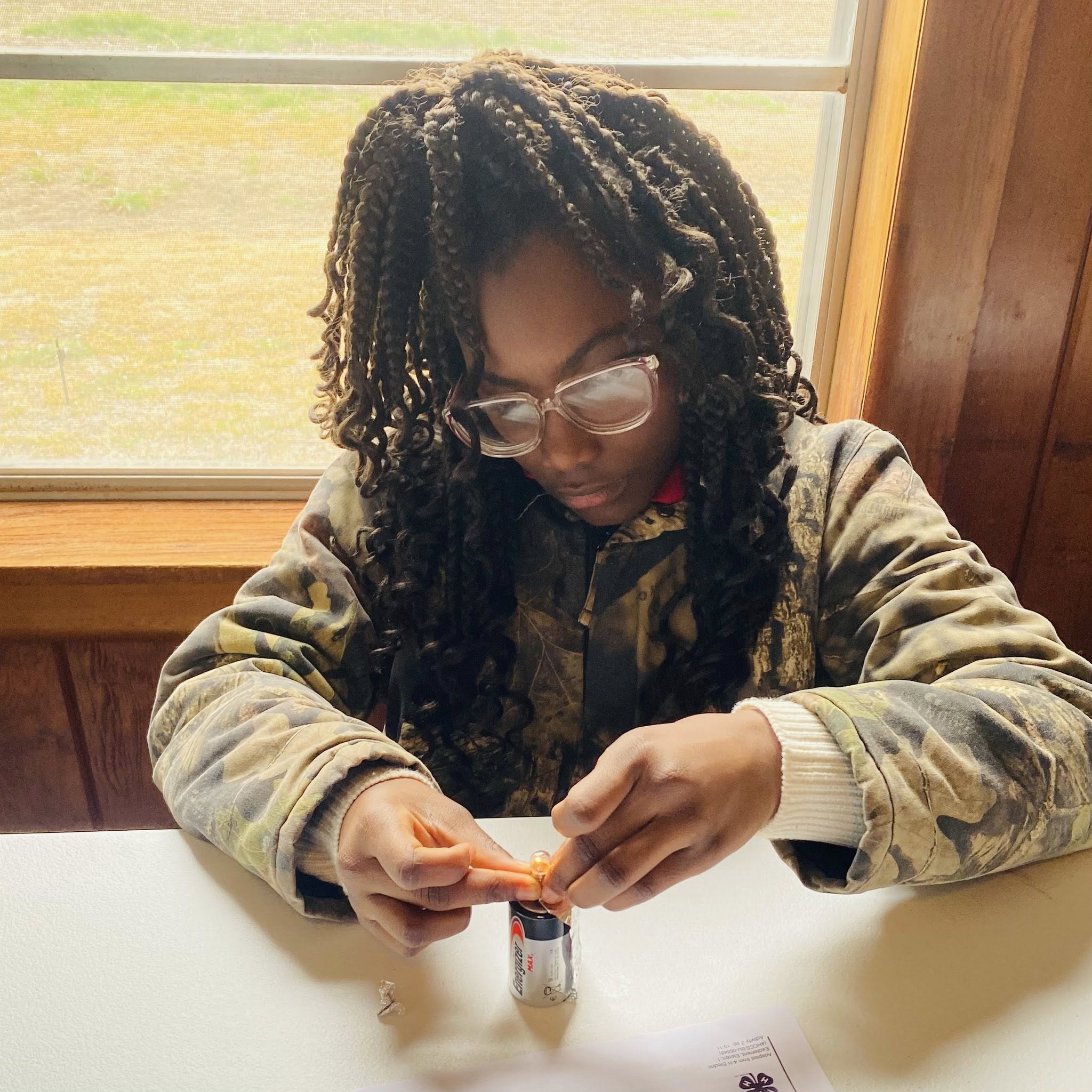 A girl working on something with a battery.
